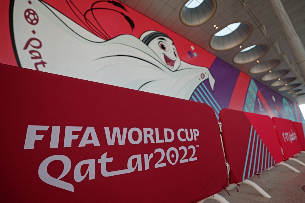 Un muro con el logo de Qatar y La'eeb, la mascota oficial del mundial