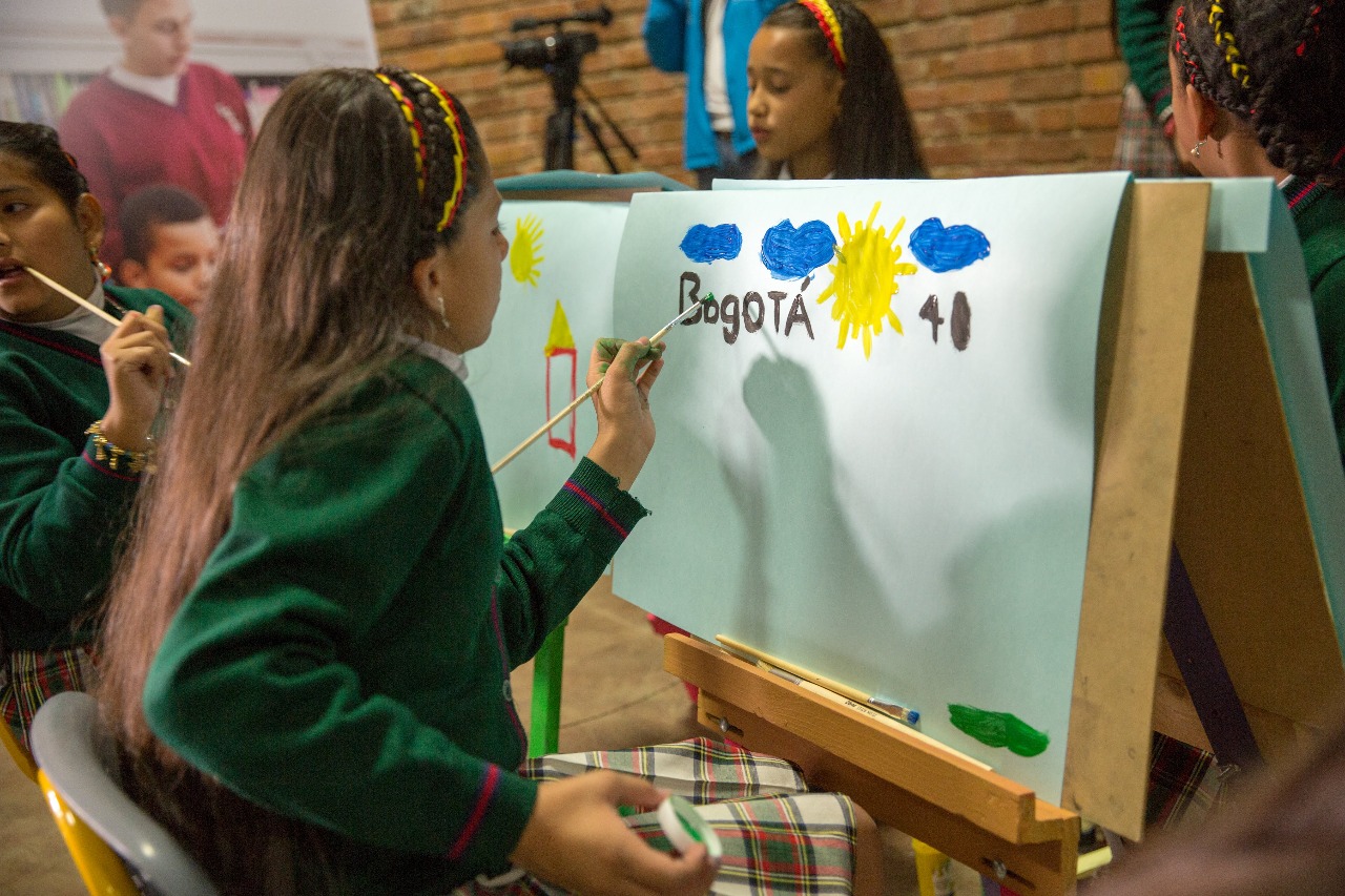 Niña pintando a Bogotá