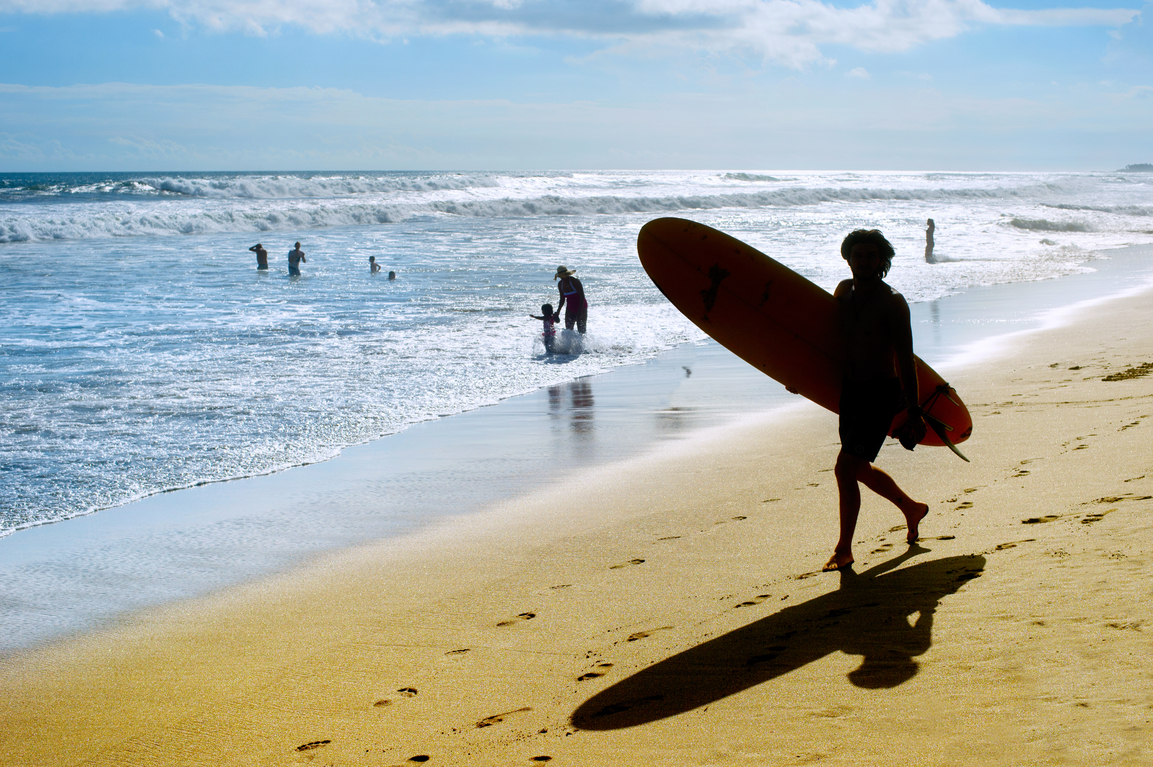 Un joven practicando surf en sus vacaciones