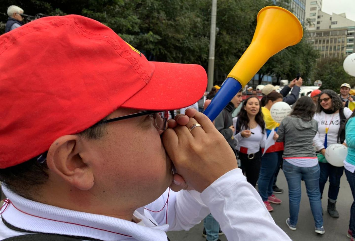 Con vuvuzelas y carteles de agrupan los manifestantes.