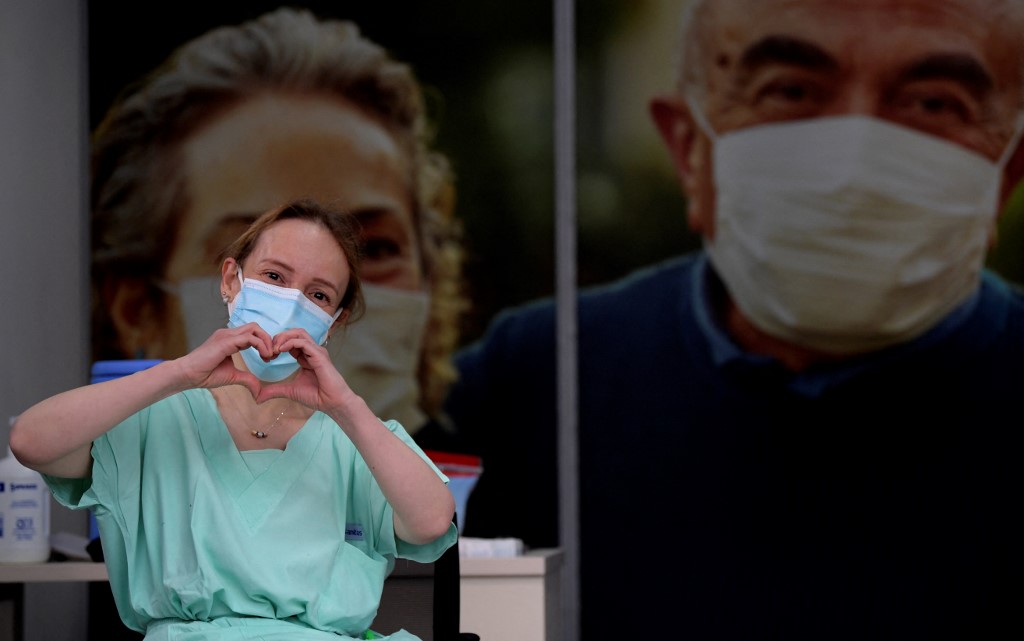 La doctora Silvia Gelvez hace gestos tras recibir una dosis de la vacuna Pfizer