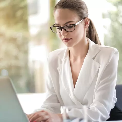 Mujer escribiendo en un computador 