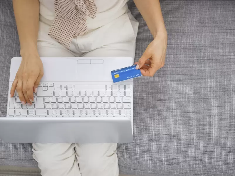Mujer haciendo un transacción con tarjeta de crédito vía web Mujer haciendo un transacción con tarjeta de crédito vía web