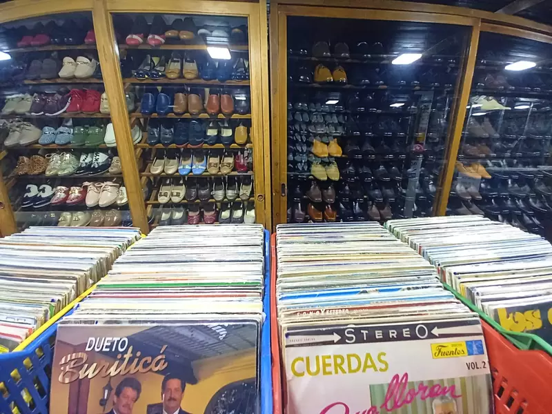 Zapatos que comparten estanter a con vinilos en el centro de
