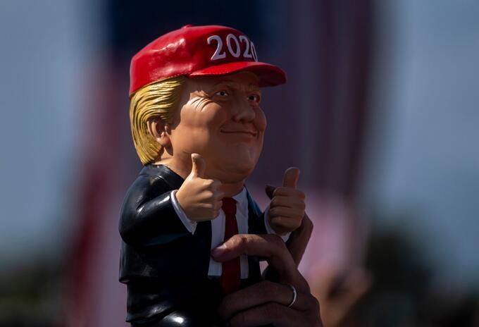 Seguidor de Donald Trump sostiene un muñeco de presidente en un evento en Tampa, Florida