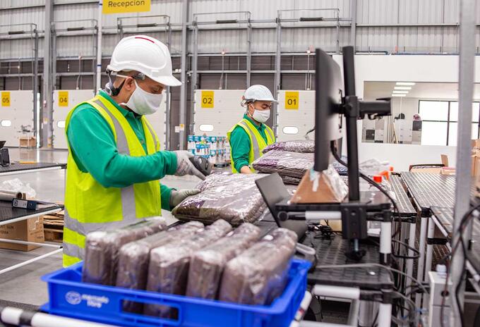 Trabajadores en centro de despacho de Mercado Libre