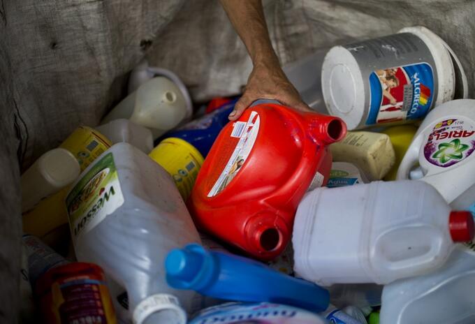 Hombre recolecta botellas de plástico en un depósito de reciclaje en Cali.