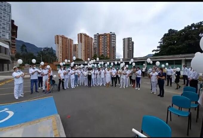 Los compañeros elevaron globos blancos para despedir al auxiliar de enfermería.