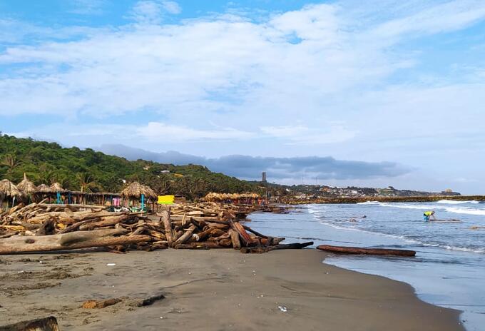 Los restos de madera están apilados en sectores de las playas mientras son recogidos.