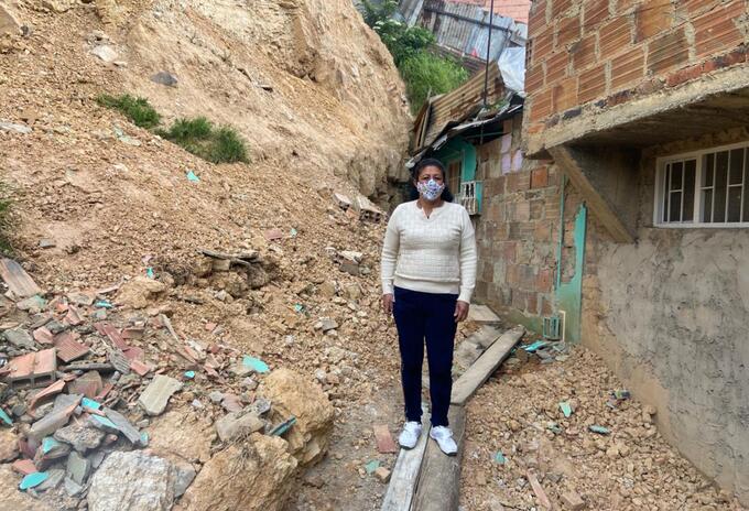 Betsabé Triana y su casa que quedó casi destruida por derrumbe de montaña.