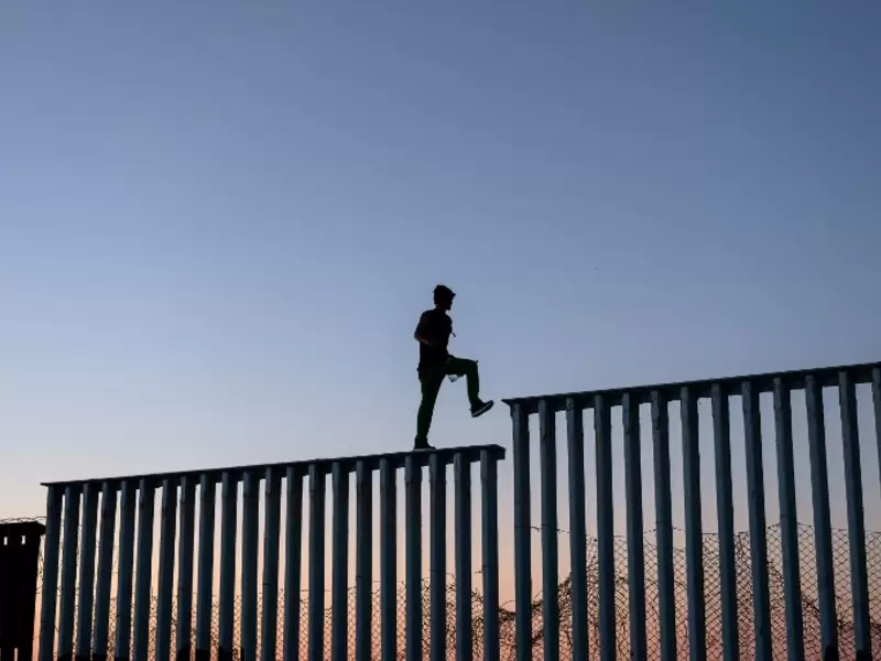 Migrantes en el muro entre México y Estados Unidos