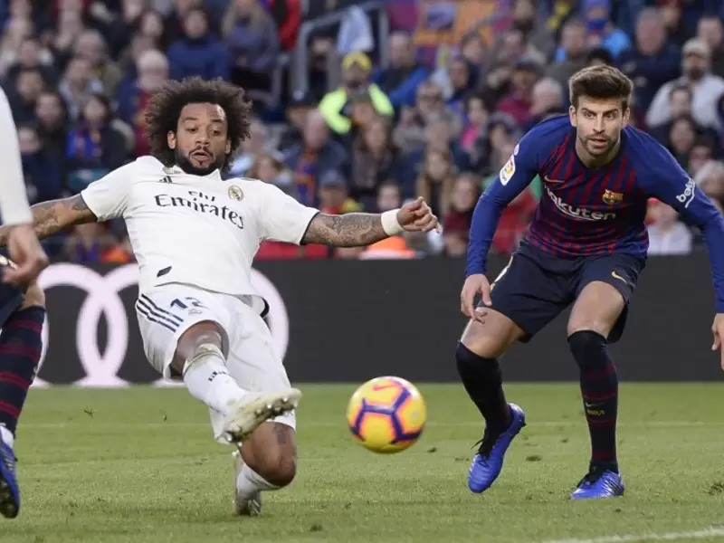 Marcelo y Piqué disputan un balón en un clásico español Marcelo y Piqué disputan un balón en un clásico español