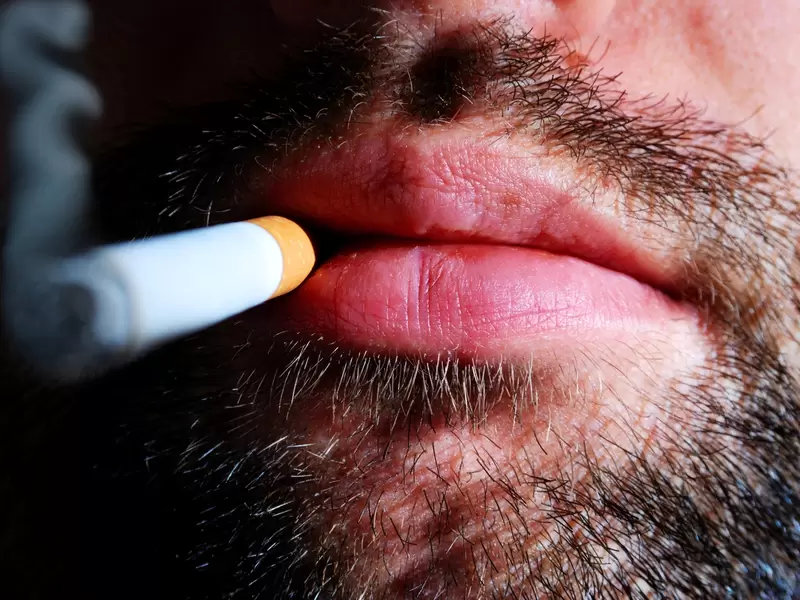 Un hombre fumando un cigarrillo Un hombre fumando un cigarrillo