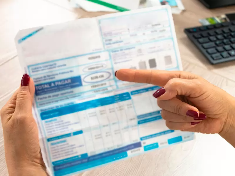 Una colombiano mirando una factura de uno de sus servicios públicos