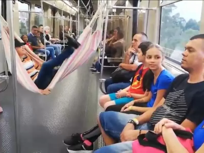 Un hombre cuelga una hamaca en pleno vagón del Metro de Medellín.