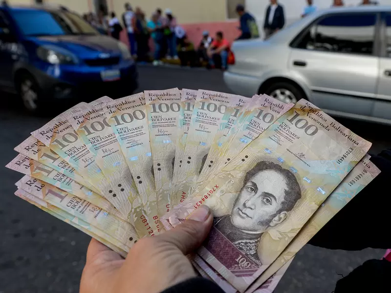 Un ciudadano venezolano expone bolívares, moneda oficial, en las calles de Caracas