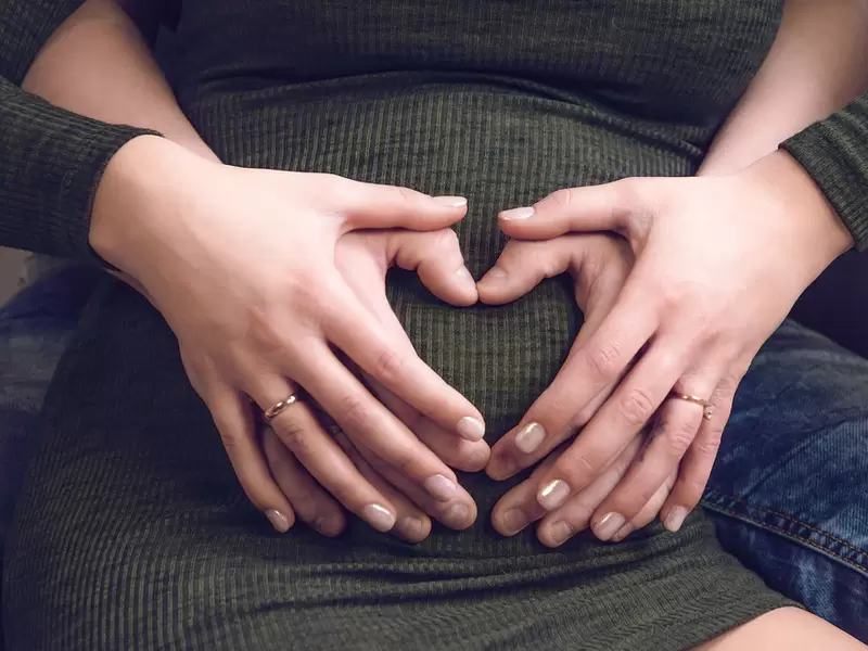 Una mujer siendo abrazada por su pareja