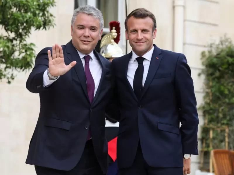 El presidente francés Emmanuel Macron (d) posa con el presidente Ivan Duque (i).