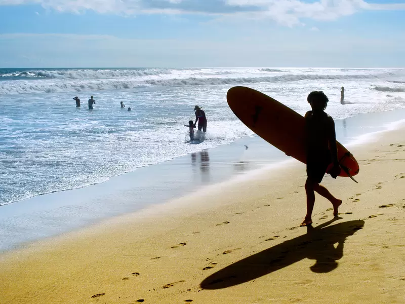 Un joven practicando surf en sus vacaciones