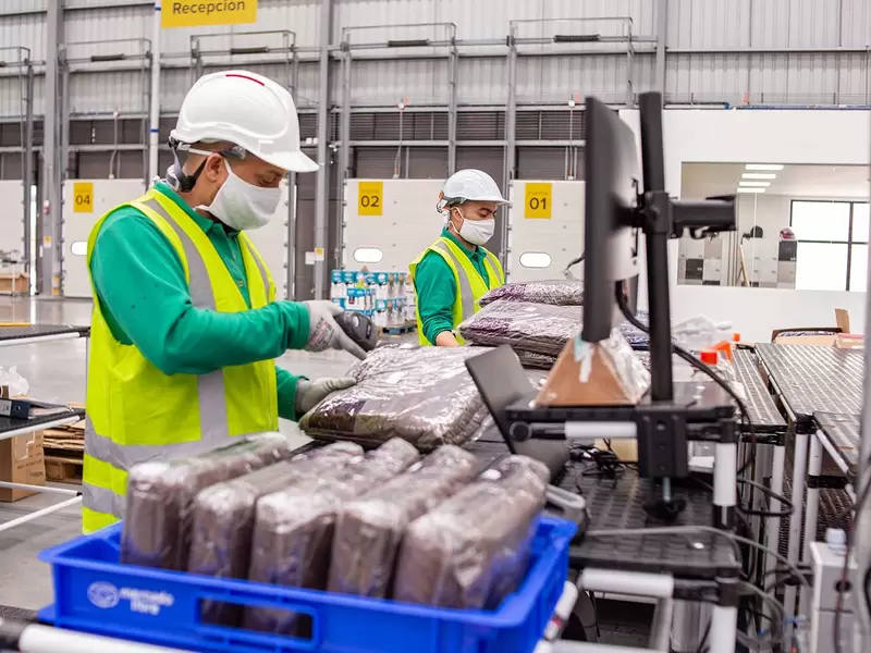 Trabajadores en centro de despacho de Mercado Libre