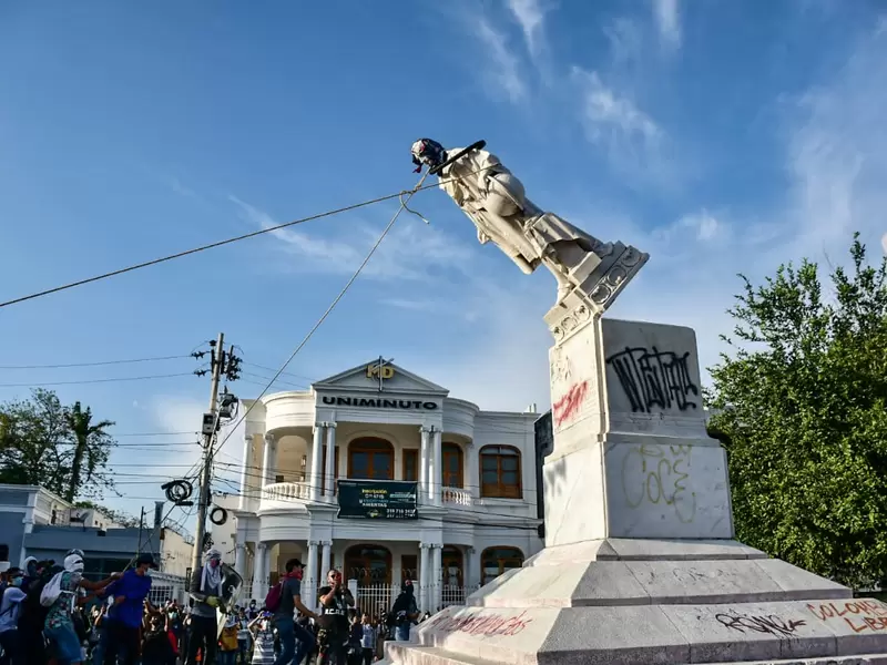 Manifestantes derriban estatua de Cristobal Colon.