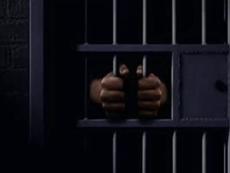 Manos tras la rejas de una cárcel