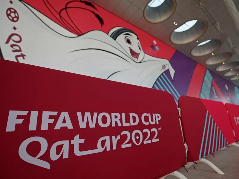 Un muro con el logo de Qatar y La'eeb, la mascota oficial del mundial