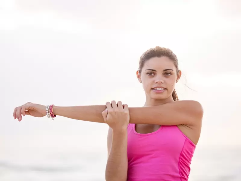 Pausas activas: cuándo deben hacerse Mujer hace estiramientos al aire libre