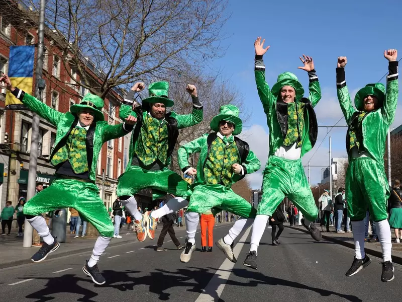 Celebración del Día de San Patricio cinco hombres saltando en el Día de San Patricio